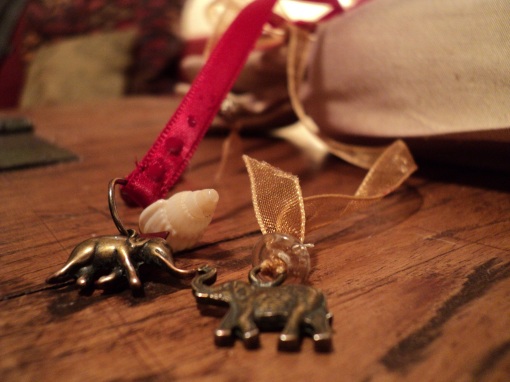 I will never forget.  Elephants for remembrance and garnet beads to symbolise drops of blood.